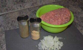Låt oss förbereda ingredienserna till fyllningen. Tina köttfärs i förväg. Skala och hacka löken.