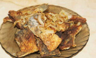Ilipat ang carp na niluto sa isang kawali sa mga piraso ng harina papunta sa mga nakabahaging plato, magdagdag ng piniritong sibuyas at ihain nang mainit. Bon appetit!