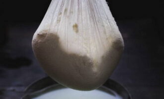 Susunod, i-hang ang cottage cheese sa gauze at mag-iwan ng isang oras upang maubos ang lahat ng likido. Ang natitirang whey ay maaaring itago at gamitin sa paggawa ng pancake.