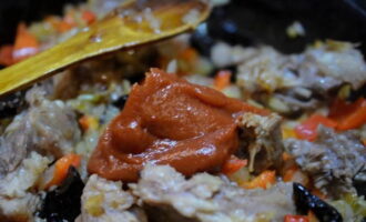 La intervale de câteva minute, se adaugă ardei dulci, prune uscate și pasta de roșii tocate în tigaia cu carne și se mai ține pe foc cam 5 minute.