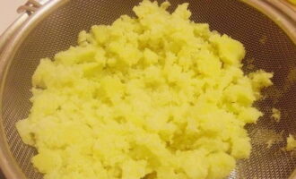 Wrijf de gekookte aardappelen door een zeef of haal ze door een pers. Droog de aardappelpuree in een pan. Breng op smaak met boter en giet de verwarmde melk erbij. Meng grondig met een garde.
