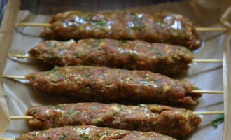 Lägg köttfärsen på träspett som har blötlagts i vatten och fördela det längs spettens längd. Lägg spetten på en plåt klädd med bakplåtspapper eller folie. Sätt på ugnen för förvärmning, ställ in sensorn på 180 grader.