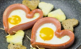 Bestrooi de spiegeleieren in de worstjes met zout en zwarte peper naar eigen smaak.