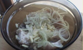 Dinadagdagan namin ang fillet na may manipis na kalahating singsing ng sibuyas at tinadtad na bawang.
