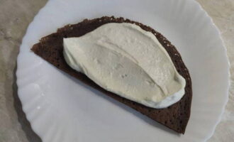 Col·loqueu un tros de pancake en un plat pla i arrebosseu-lo amb crema de mató.