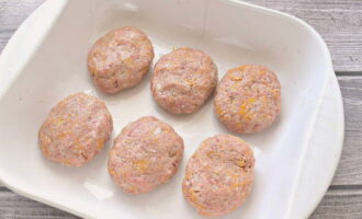 Vi formar snygga kotletter av saftigt malet kött och lägger dem på en bakplåt smord med vegetabilisk olja.