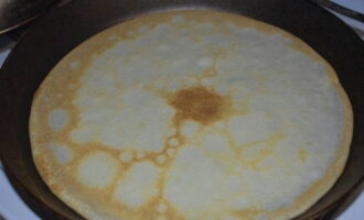 Stek sedan tunna pannkakor från den förberedda degen. Lägg en matsked smet på en het stekpanna. Fördela den över hela pannans yta och stek tills den är gyllenbrun på båda sidor.
