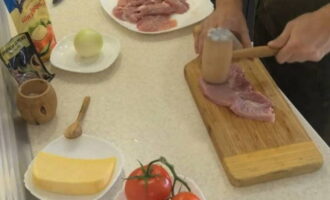 Hoe kook je heerlijk vlees in de oven? Bereid onmiddellijk, volgens het recept en het aantal porties dat u nodig heeft, alle ingrediënten voor het gerecht. Spoel het varkensvlees af, droog het af met een servet, snijd het over de draad in porties van minimaal 1 cm dik en stamp ze vervolgens aan beide kanten fijn.