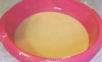 Ibuhos ang sifted na harina sa likidong base at sa parehong oras masahin ang kuwarta gamit ang isang whisk hanggang sa magkaroon ito ng homogenous at likidong texture. Takpan ang mga pinggan na may pelikula at ilagay sa isang mainit na lugar sa loob ng 1 oras.
