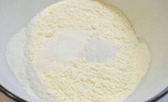 Thêm một thìa cà phê bột nở và một chút muối vào bột. Trộn đều mọi thứ bằng thìa. Đường không được thêm vào bột vì nhân có vị ngọt.