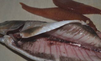 Pinutol namin ang herring kasama ang tiyan at alisin ang lahat ng mga insides, banlawan sa ilalim ng tubig na tumatakbo sa loob at labas.