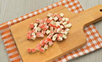 Scoateți coaja de pe produsele semifabricate de crab și tăiați-le în pătrate.
