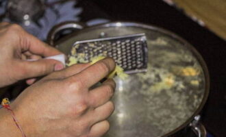 Đổ nước vào nồi và đun sôi. Nghiền củ gừng cho vào nước sôi.
