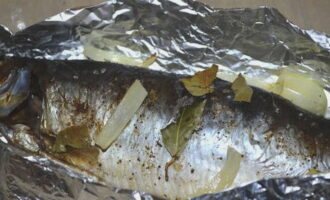 Ihurno ang isda sa 180 degrees sa loob ng 30 minuto, mga 5 minuto bago patayin, ibuka ang foil at i-brown ang herring.