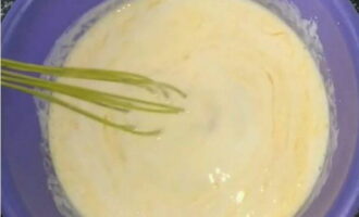 Đổ kefir đã hơi ấm vào tô để nhào bột. Đập hai quả trứng và trộn đều bằng máy đánh trứng.