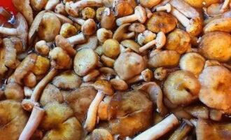 Trieu els bolets de mel de les restes del bosc. Posar en un recipient gran i omplir d'aigua. Les taques suraran cap amunt. Utilitzeu una cullera ranurada o un colador per recollir-los. Esbandida fins que l'aigua surti clara.