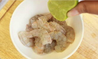 เราทำความสะอาดกุ้งจากเปลือกและเครื่องใน ใส่ในชามแล้วปรุงรสด้วยพริกไทยขาว น้ำมะนาว และเกลือเล็กน้อย ผสมให้เข้ากันแล้วปล่อยให้แช่ไว้ 15 นาที
