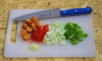 Skär korvarna i skivor. Hacka lök, tomat, paprika och vitlök.