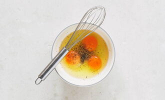 Trong một bát sâu riêng biệt, kết hợp trứng gà. Thành phần muối và hạt tiêu. Trộn bằng máy đánh trứng.