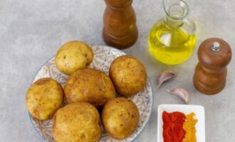 Rentar bé les patates amb un raspall per netejar completament la superfície de la terra. Enceneu el forn amb antelació i ajusteu la temperatura a 200-220 graus. 