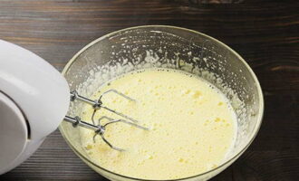 Ngayon ihanda natin ang jellied dough. Talunin ang mga itlog na may asukal hanggang sa makakuha ka ng isang malambot na puting masa. Ang mga nilalaman ng ulam ay dapat na kapansin-pansing tumaas sa dami.