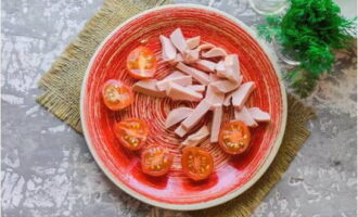 Skär de tvättade tomaterna på mitten och hacka korven slumpmässigt. Värm samtidigt vegetabilisk olja i en stekpanna.