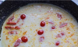 Häll ägg-mjölksblandningen över tomaterna och rör om lätt.