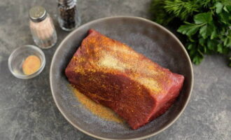 Col·loqueu el filet de carn en una taula de tallar o en un bol ample. Espolseu-ho amb all sec, condiment de carn i pebre vermell fumat.