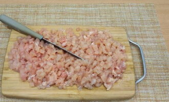 Așezați pieptul de pui pe o masă de tăiat și tăiați-l în bucăți foarte mici de orice formă.