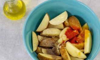 Afegiu també totes les espècies preparades i sal, afegiu oli vegetal. Llenceu suaument les falques de patata fins que quedin uniformement cobertes amb les espècies i l'oli.