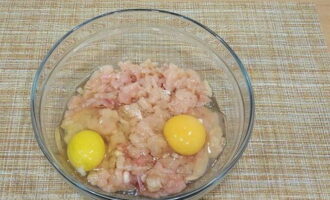 Puneți carnea tocată într-un castron, spargeți ambele ouă de pui în ea. 