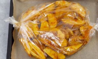 Cobriu una safata de forn amb pergamí. Col·loqueu les patates preparades a la funda de forn, fixeu-ne les vores i distribuïu-hi les patates en una capa uniforme perquè s'enfornin millor.