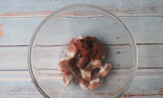 Skölj fläsket med vatten och låt torka, skär i medelstora tärningar och lägg över på en tallrik.Vi kompletterar komponenten med tomatpuré, salt och mald peppar - blanda.