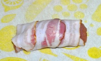 Vékony szalonnaszeleteket készítünk. Csirketekercsre tekerjük őket. Fogpiszkálóval megtűzzük őket. Sütés után kivehetők, a finomság megtartja a kívánt formát.