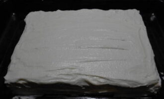 Cobriu-ho amb la segona capa de pastís. Cobreix tota la peça amb la crema restant.