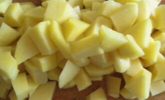 Rentem les patates i traiem les peles fent servir una mestressa. Tallar a daus. Al mateix temps, poseu una paella amb aigua perquè s'escalfi. Rentem les patates i traiem les peles fent servir una mestressa. Tallar a daus. Al mateix temps, poseu una paella amb aigua perquè s'escalfi.