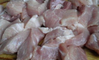 Talleu la carn de porc a trossos petits.