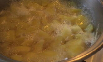Aboqueu una mica de sal a l'aigua bullint i transferiu les patates preparades. Després de tornar a bullir, reduïu el foc i deixeu-ho coure fins que estigui tendre, cobrint amb una tapa. Aboqueu una mica de sal a l'aigua bullint i transferiu les patates preparades. Després de tornar a bullir, reduïu el foc i deixeu-ho coure fins que estigui tendre, cobrint amb una tapa.