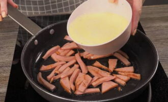 Skär den kokta korven i små bitar och stek tills den är lätt brynt i het vegetabilisk olja. Häll omelettblandningen över den stekta korven.
