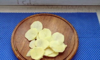 Scoateți coaja de cartofi, spălați și tăiați felii.