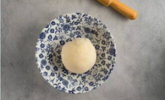 För att förbereda degen, kombinera salt och mjöl i en djup skål, tillsätt det återstående vattnet och knåda till en homogen klump.