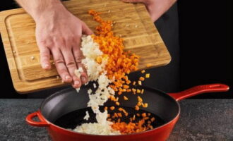 Curățați ceapa și morcovii, clătiți cu apă și tăiați cubulețe mici. Sotește legumele în ulei vegetal încălzit până când sunt moale și aurii.