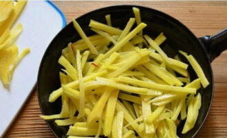 Prăjiți cartofii în ulei vegetal încins până când sunt complet fierți.