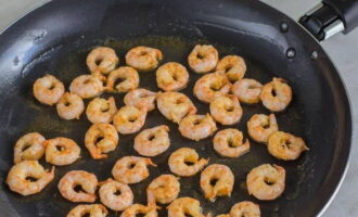Escalfeu la paella a foc mitjà i foneu una mica de mantega. Distribuïu les gambes marinades. Fregir ràpidament pels dos costats.