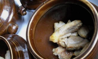 Poseu la carn de porc fregida a les olles preparades.