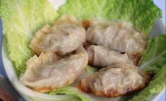 Chinese dumplings zijn klaar! Plaats de rooskleurige schaal op vellen Chinese kool en proef door hem in sojasaus te dopen. Eet smakelijk! 