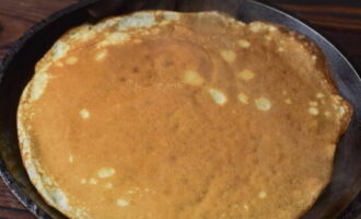 Încinge bine tigaia. Se toarnă puțin aluat aici și se întinde pe suprafață. Prăjiți clătitele în acest fel până când se rumenesc pe ambele părți.