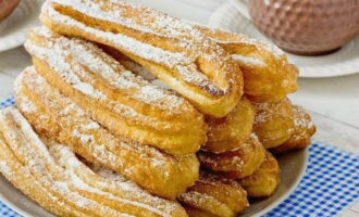 Se presară churros cu zahăr pudră, se stivuiește pe un platou și se servește. Poftă bună!