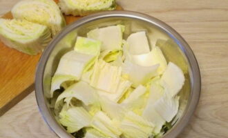 Rửa sạch đầu bắp cải, trải lá ra để không còn cát. Cắt rau thành khối lớn. Muối các miếng bắp cải rồi cho vào tô, để muối và tiết ra nước.