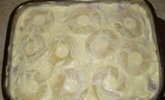 Susunod, ikalat ang mga hiwa ng de-latang pinya sa ibabaw ng layer ng karne. Pahiran din ng mayonesa ang layer na ito.